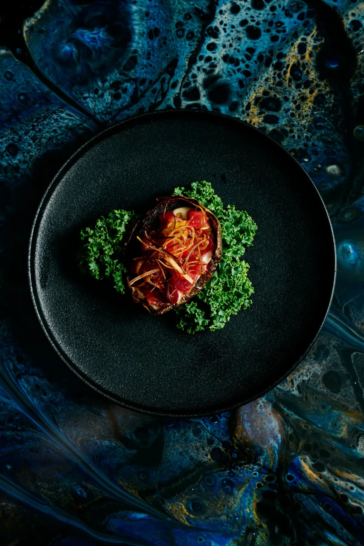 A glazed course on curly kale in a black bowl