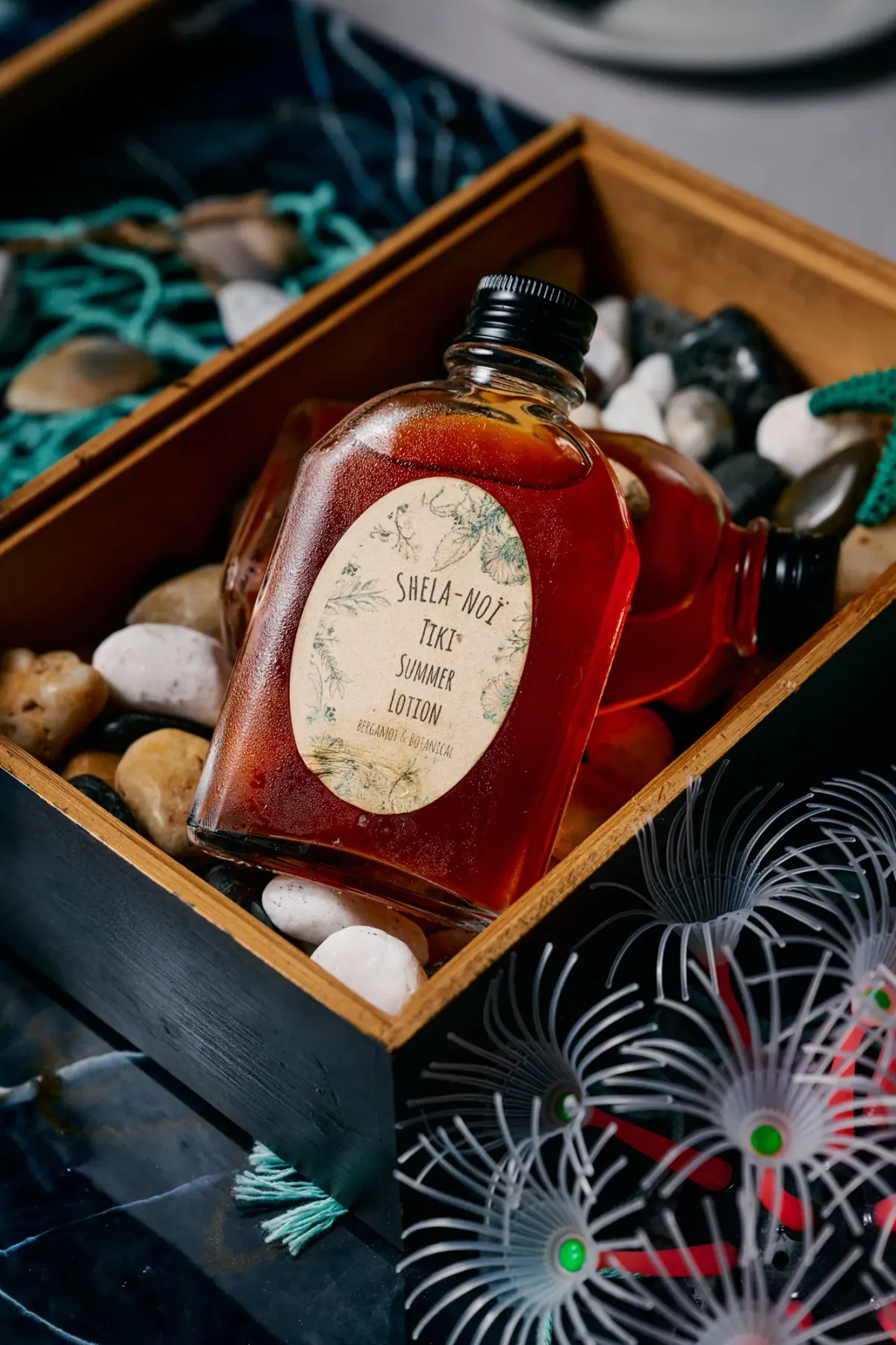 A bottle of the house Tiki summer syrup in a crate of river stones